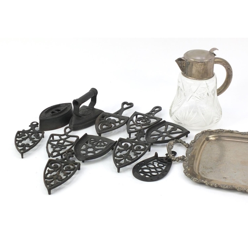 301 - Silver plated twin handled tray, cut glass wine jug and Victorian flat irons and trivets