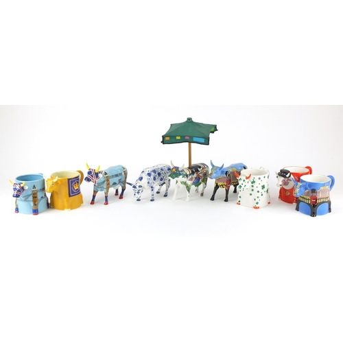 2216 - Four collectable Cow Parade cows and five mugs the cows including Bovingham Palace and Cower Bridge,... 