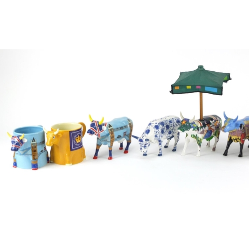 2216 - Four collectable Cow Parade cows and five mugs the cows including Bovingham Palace and Cower Bridge,... 