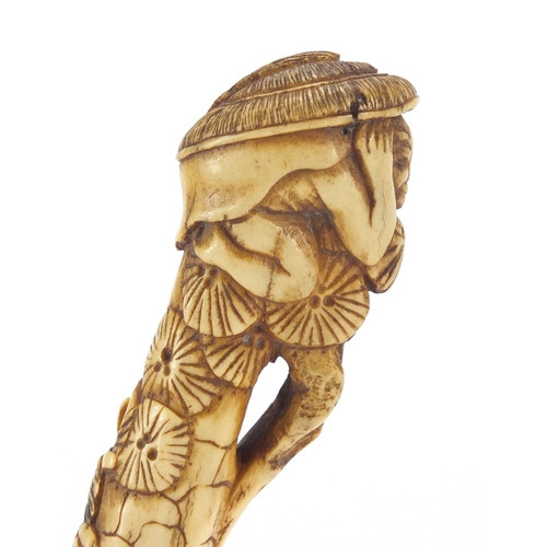 609 - Chinese bone parasol handle carved with two figures and trees, 16cm in length