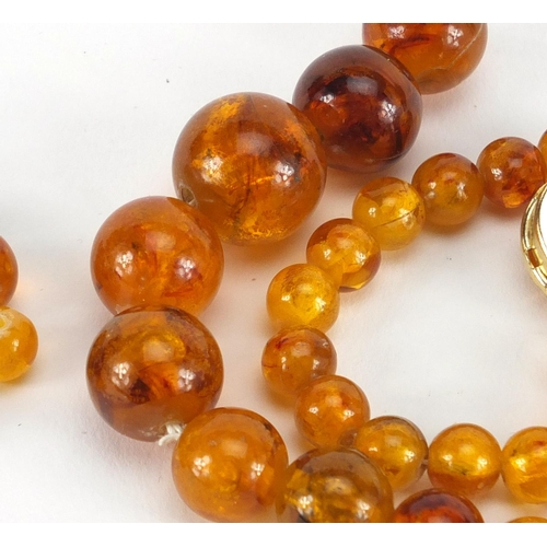351 - Amber coloured bead necklace, two brooches and loose beads, approximate weight 38.6g