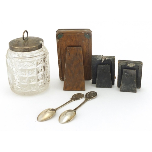 2273 - Silver items comprising cut glass preserve jar, two teaspoons and three miniature easel photo frames