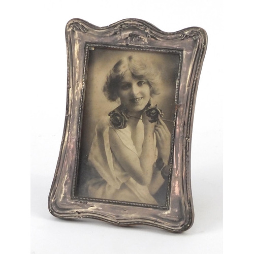 574 - Silver easel photo frame with embossed decoration, Birmingham hallmarked, 18cm high