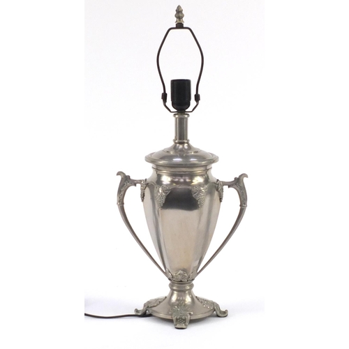 217 - Silvered metal twin handled lamp decorated with grapevines, 59cm high