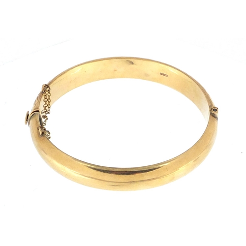 2354 - 9ct gold bangle with floral chased decoration, approximate weight 13.5g