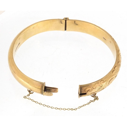 2354 - 9ct gold bangle with floral chased decoration, approximate weight 13.5g