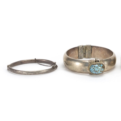 2409 - Four silver bangles, two with floral chased decoration and one set with cabochon turquoise, approxim... 
