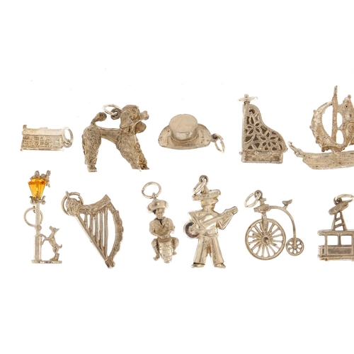 2406 - Fifteen silver and white metal charms including grand piano, harp, street lantern and poodle, approx... 