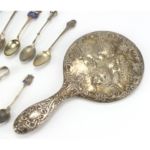575 - Silver backed hand mirror, teaspoons and sugar tongs, some with enamelled terminals