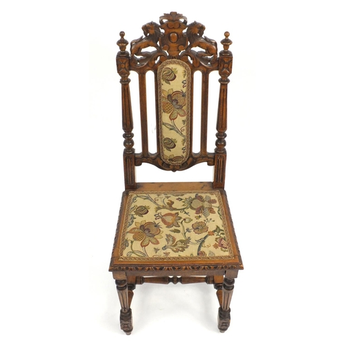 2 - Oak occasional chair carved with a lion crest and needlepoint upholstery, 113cm high