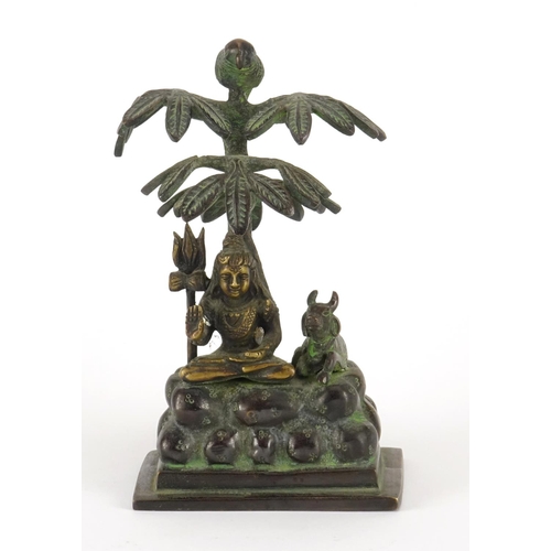 226 - Middle Eastern patinated bronze study of a deity under a tree, 17cm high