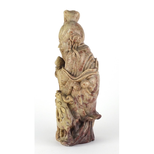 560 - Chinese russet and red soapstone carving of an elder holding a staff with a goat, 22cm high