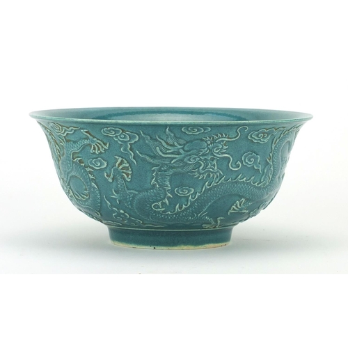 492 - Chinese porcelain turquoise glazed footed bowl, decorated in relief with three dragons amongst cloud... 