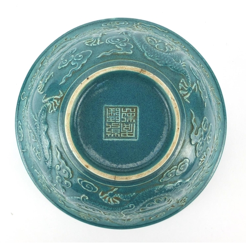 492 - Chinese porcelain turquoise glazed footed bowl, decorated in relief with three dragons amongst cloud... 
