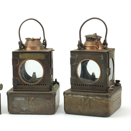 87 - Four Welch patent railway lamps, three with ceramic burners, each with various plaques including a F... 