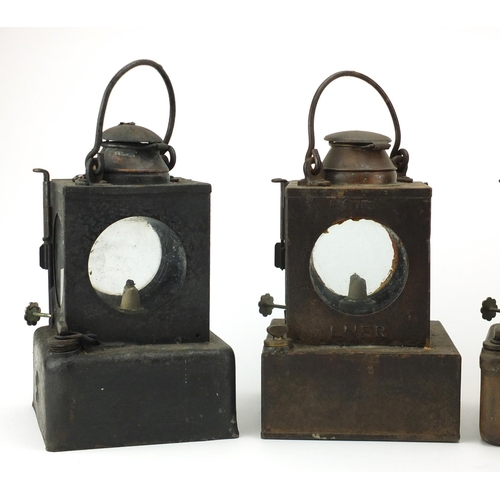 87 - Four Welch patent railway lamps, three with ceramic burners, each with various plaques including a F... 