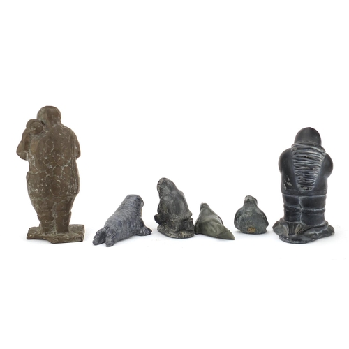 655 - Five Inuit figures including four stone carvings and a large bronzed Eskimo, some with paper labels,... 