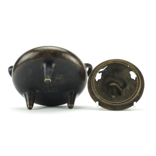 564 - Chinese patinated bronze tripod incense burner and cover with twin handles, character marks to the b... 