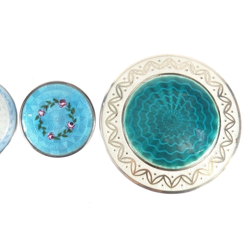 811 - Four silver and guilloche enamel circular brooches hand painted with roses, the largest 5cm in diame... 