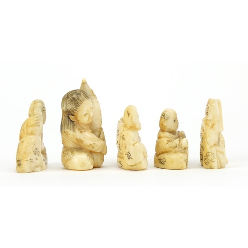 523 - Four Japanese carved ivory netsuke's and an okimono of a figure holding a gourd, three with characte... 