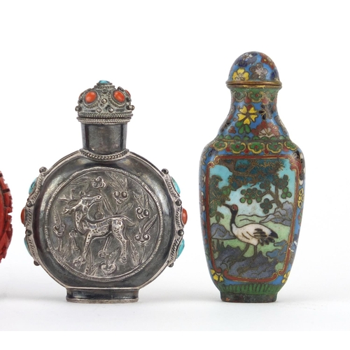 536 - Four Chinese snuff bottles including an unmarked silver example decorated in relief with two deer's ... 