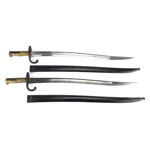 370 - Two French Military interest long bayonets with scabbards, both with impressed marks, each 71cm in l... 