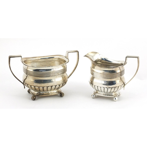 865 - Victorian silver demi fluted twin handled sugar bowl and matching cream jug, both with ball feet, by... 