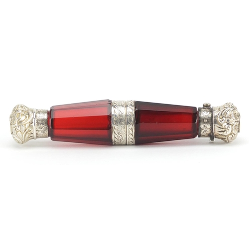56 - Victorian ruby glass binocular double ended scent bottle having embossed unmarked silver mounts, 14c... 