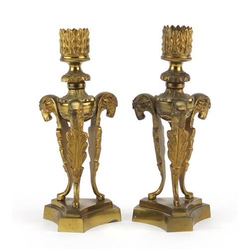 13 - Pair of 19th century gilt bronze ram design candlesticks raised on triangular bases, 18cm high