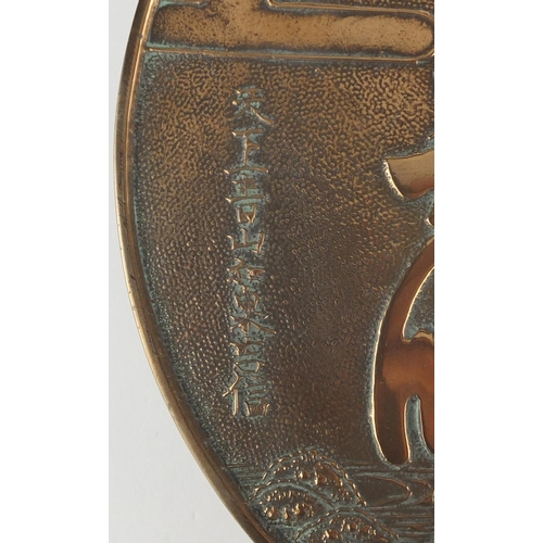 571 - Two Japanese bronze hand mirrors cast with cranes, flowers and script, the largest  32cm in length