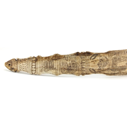 101 - Scrimshaw style bone section carved with creatures and symbols, 39.5cm in length