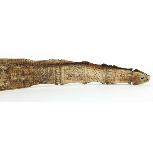 101 - Scrimshaw style bone section carved with creatures and symbols, 39.5cm in length