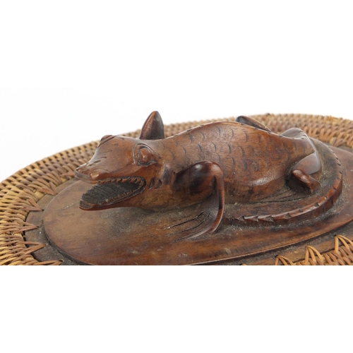 586 - Oriental oval wicker and hardwood container carved with a lizard, 16cm wide