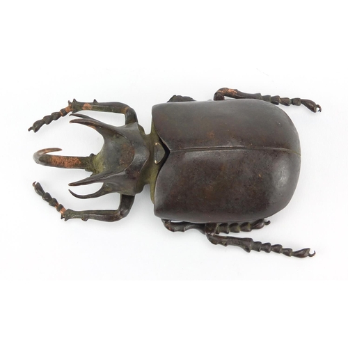 572 - Japanese patinated bronze rhinoceros beetles, with hinged wings and articulate legs, impressed chara... 