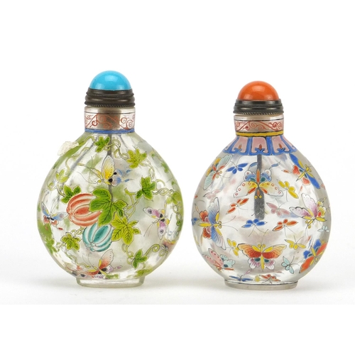 538 - Two Chinese glass snuff bottles with stoppers, each enamelled with butterflies, character marks to t... 