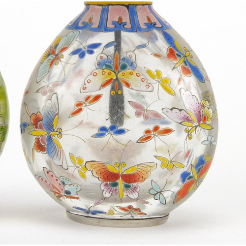 538 - Two Chinese glass snuff bottles with stoppers, each enamelled with butterflies, character marks to t... 