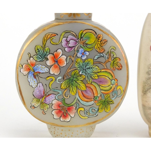 537 - Two Chinese glass snuff bottles with stoppers, one enamelled with butterflies amongst flowers, the o... 