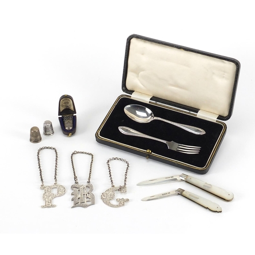869 - Silver objects including fork and spoon Christening set, three thimbles, two mother of pearl flanked... 