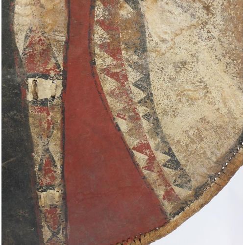 663 - Tribal interest Maasai shield and spear, the shield hand painted with a geometric decoration, the sh... 