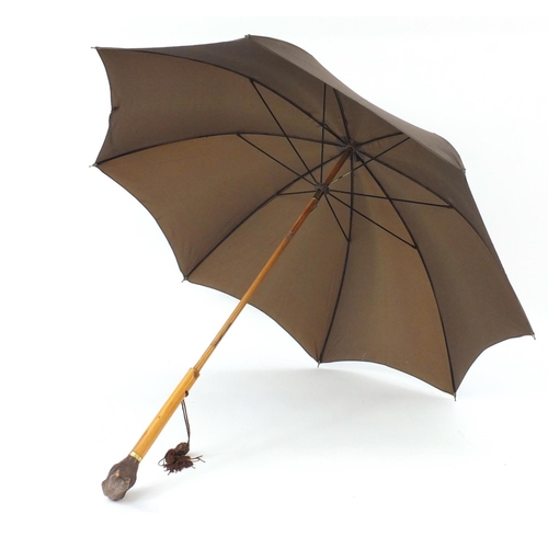 109 - Black Forest parasol with carved rabbit head handle and 18ct gold plated collar, 90.5cm in length