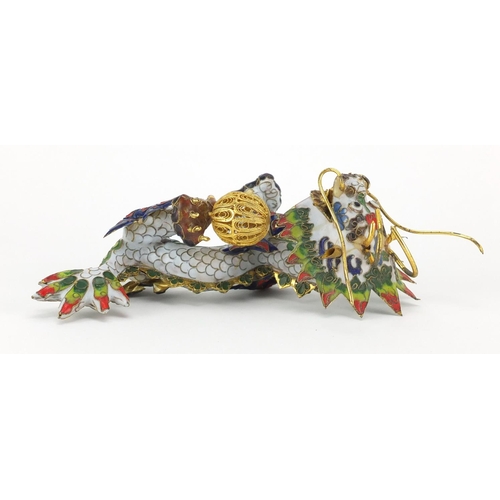 554 - Chinese gilt metal and enamel dragon raised on hardwood stand, 22.5cm in length