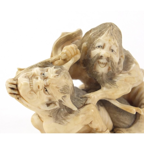515 - Good Japanese carved ivory okimono of a Samurai catching a demon, 10cm in length