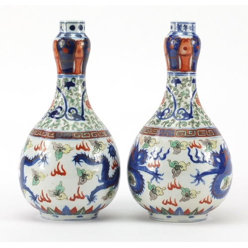 391 - Pair of Chinese porcelain doucai bottle vases, hand painted with flower heads and foliate scrolls am... 