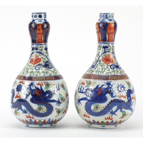 391 - Pair of Chinese porcelain doucai bottle vases, hand painted with flower heads and foliate scrolls am... 