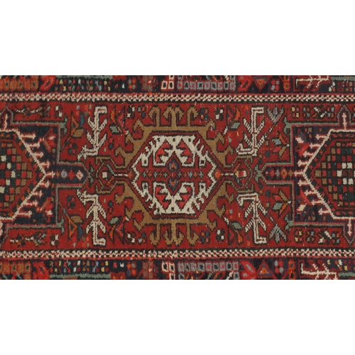 2127 - Rectangular Persian Heriz carpet runner, the central field having a stylised repeat flower head desi... 