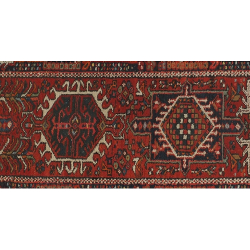 2127 - Rectangular Persian Heriz carpet runner, the central field having a stylised repeat flower head desi... 