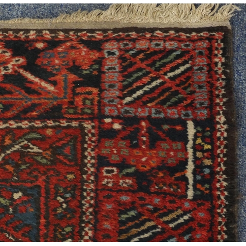 2127 - Rectangular Persian Heriz carpet runner, the central field having a stylised repeat flower head desi... 