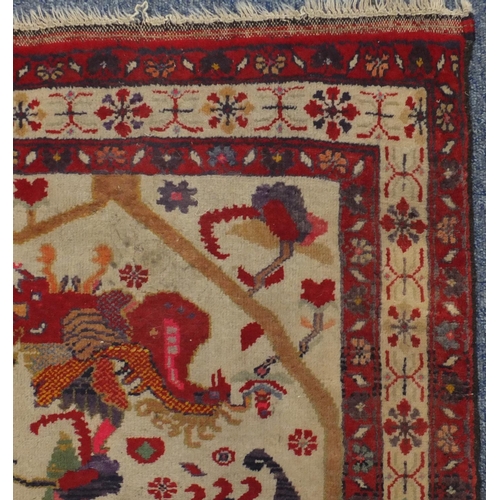 2116 - Rectangular Persian rug, the central field depicting birds of paradise and flowers onto an ivory fie... 