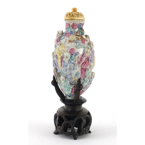 395 - Good Chinese porcelain relief snuff bottle with ivory stopper, raised on a carved hardwood stand, ha... 