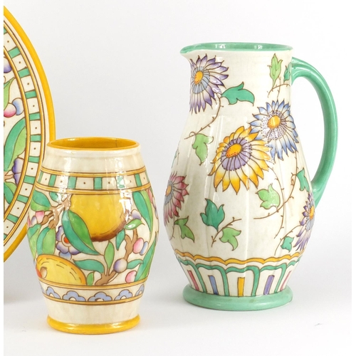 2301 - Bursley Ware by Charlotte Rhead comprising a charger, jug and vase, each hand painted with stylised ... 